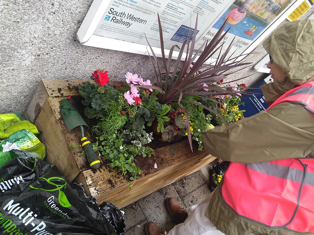 Planter near the station entrance being planted up