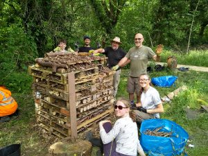 Volunteers posing fo a photo around the completed bug hotel